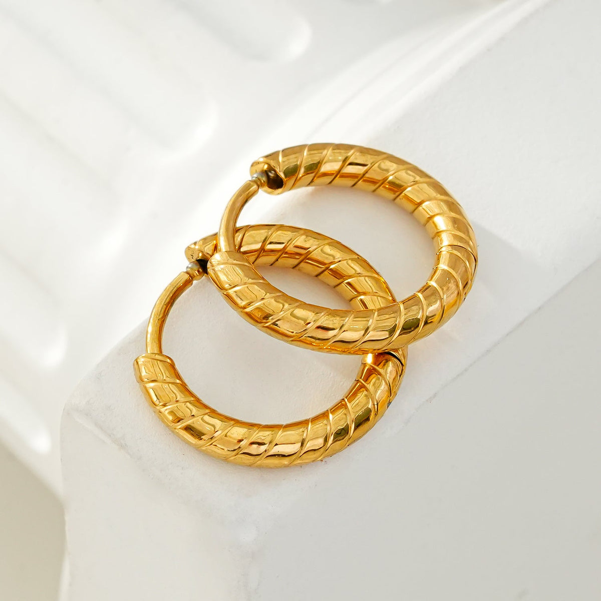 LUPITA : Boucles d'oreilles créoles texturées à motif tourbillon dorées