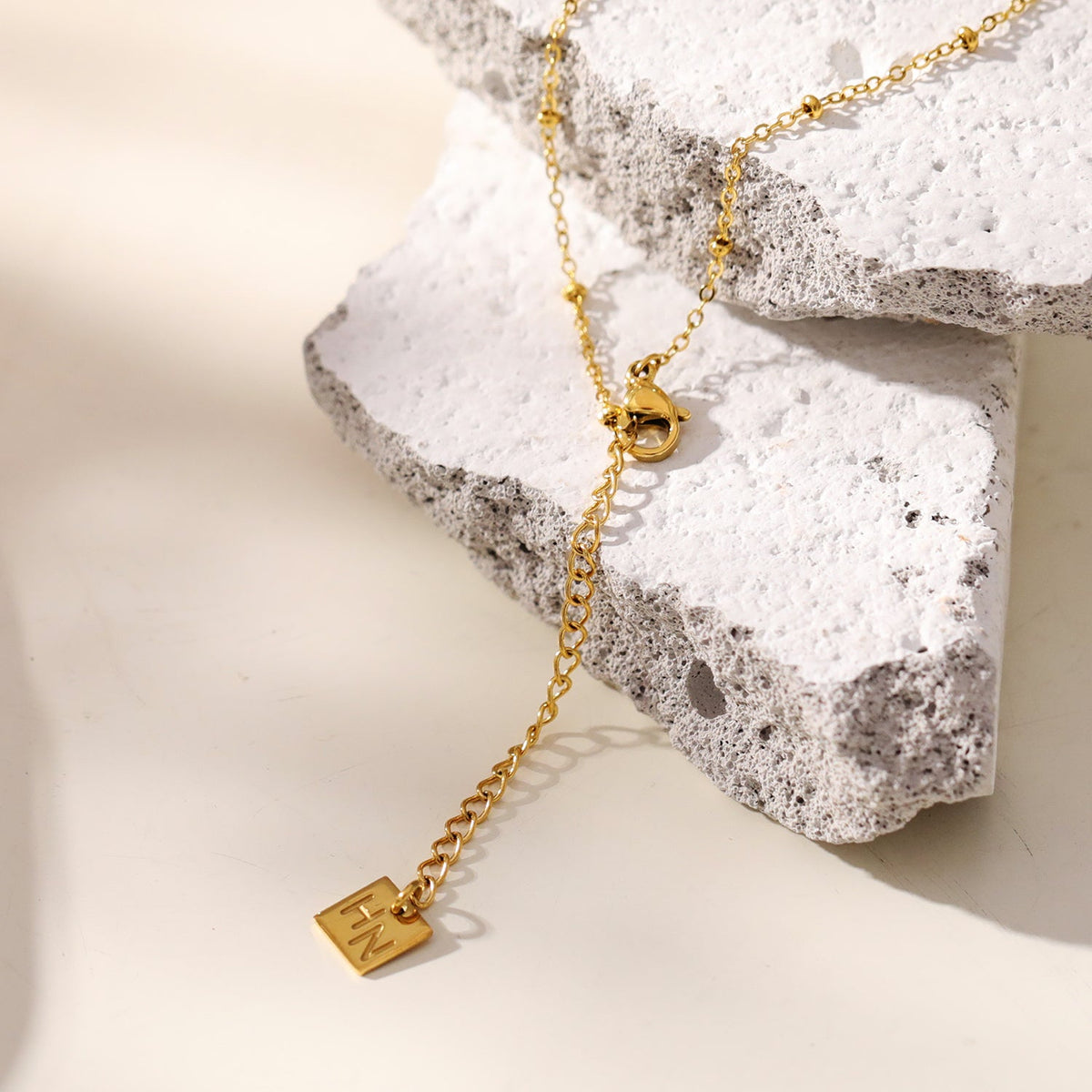 CHAMONIX Or : Collier chaîne fine perlée avec pendentif croix texturée incrustée de zircone