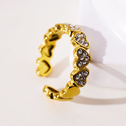 JEZREEL : Bague cernée de mini-breloques en forme de cœur avec cristaux de zircone au centre