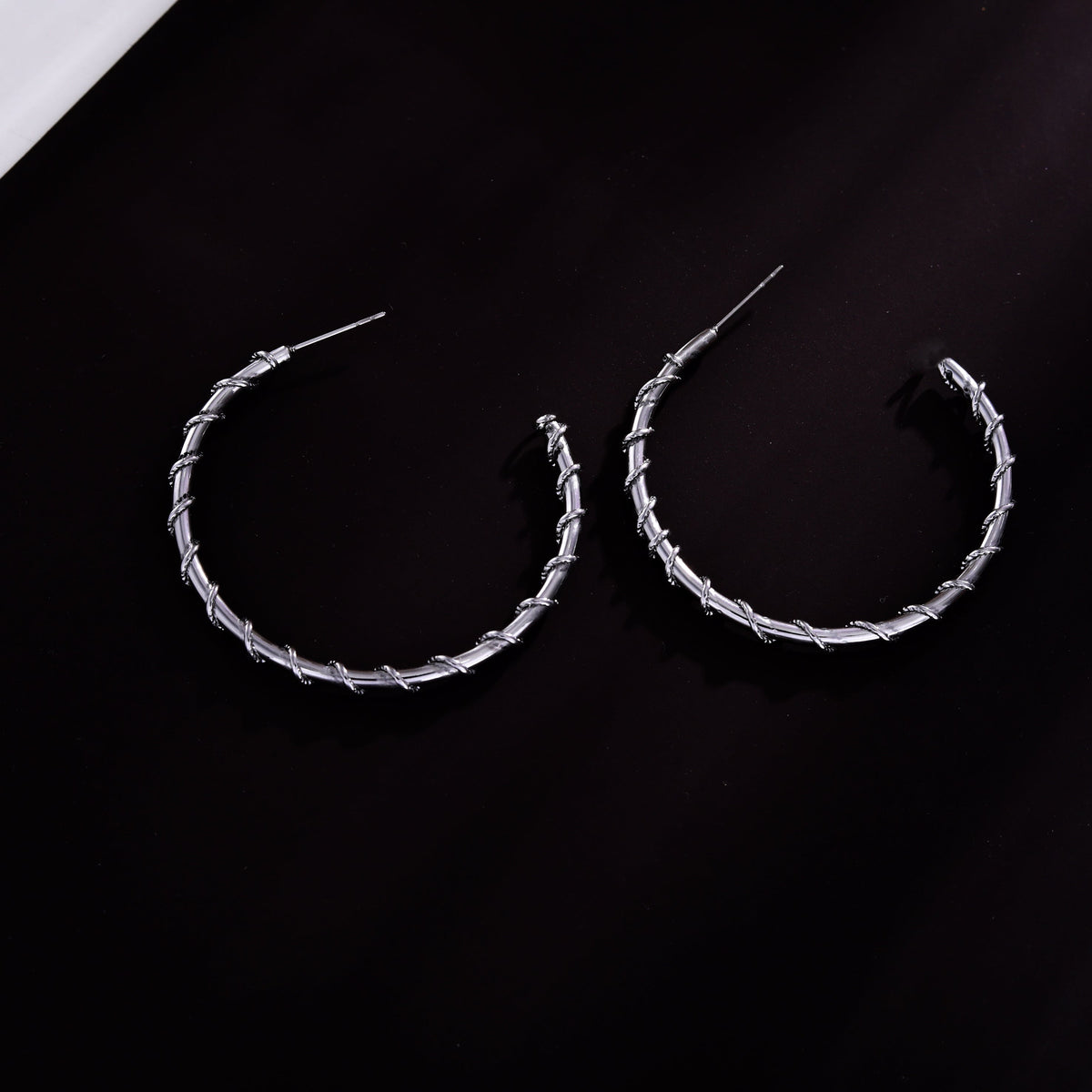 Boucles d'oreilles créoles ELNA argentées avec une torsade décorative