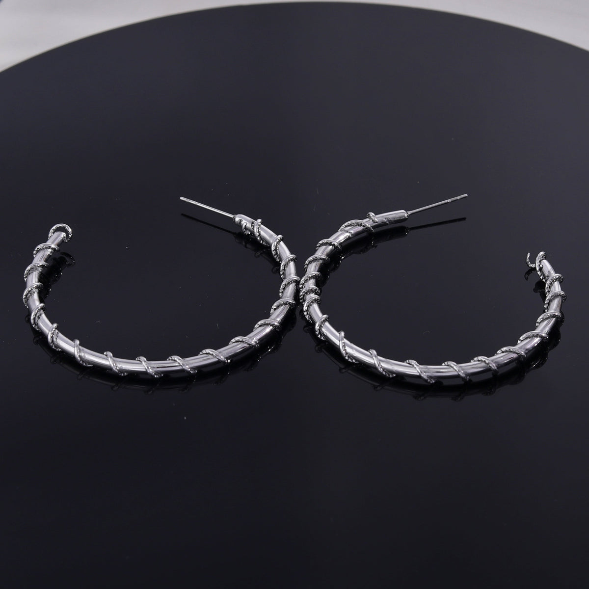 Boucles d'oreilles créoles ELNA argentées avec une torsade décorative