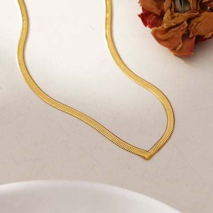 Collier GAURI asymétrique avec chaîne dorée texturée peau de serpent
