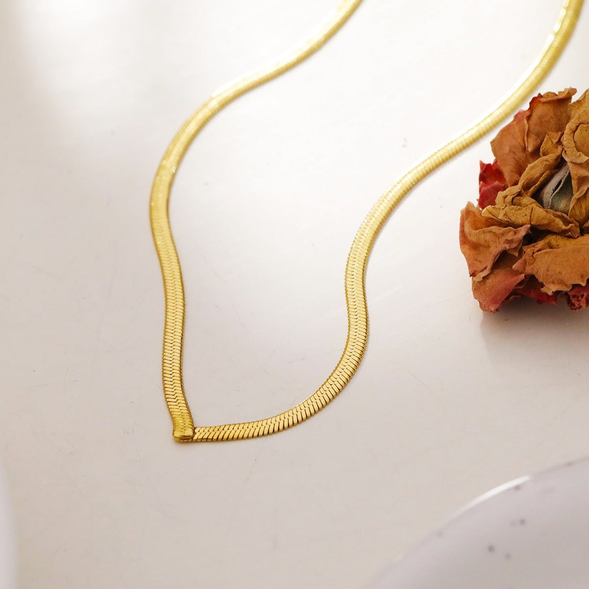 Collier GAURI asymétrique avec chaîne dorée texturée peau de serpent