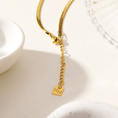 Collier GAURI asymétrique avec chaîne dorée texturée peau de serpent